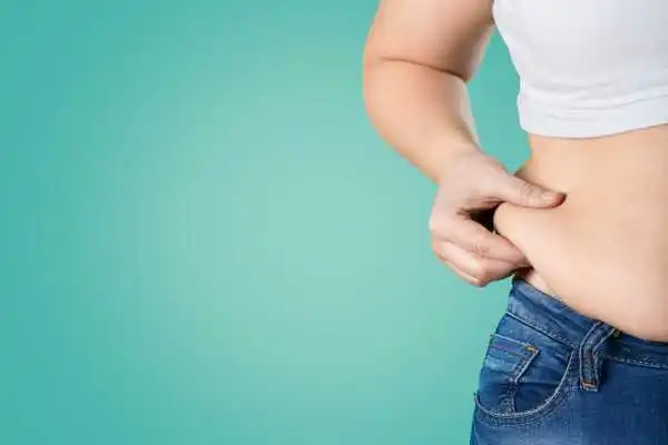 Image of woman pinching her love handles to show weight gain Redditch