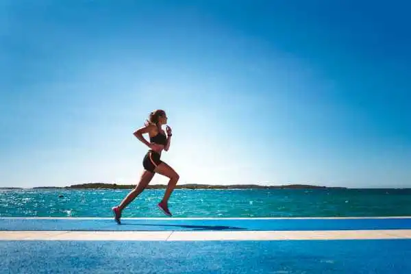 Woman running showing strong leg muscle Redditch